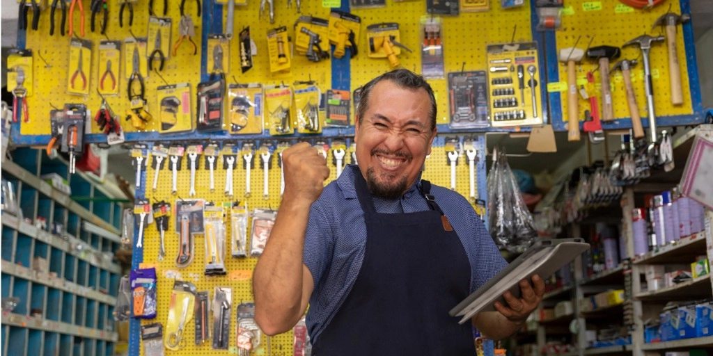 Home services business owner celebrating with tablet